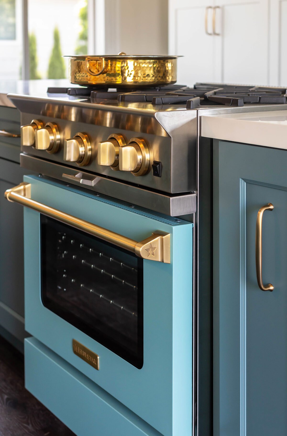 a blue color kitchen range with gold knobs