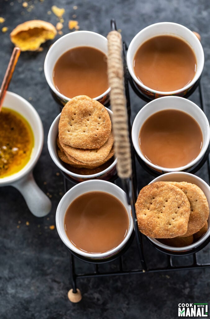 glasses of chai and glasses filled with mathri arranged in a glass holder