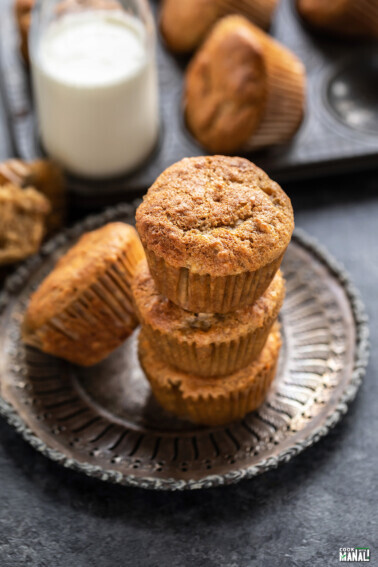 3 muffins stacked together with bottle of milk in the background