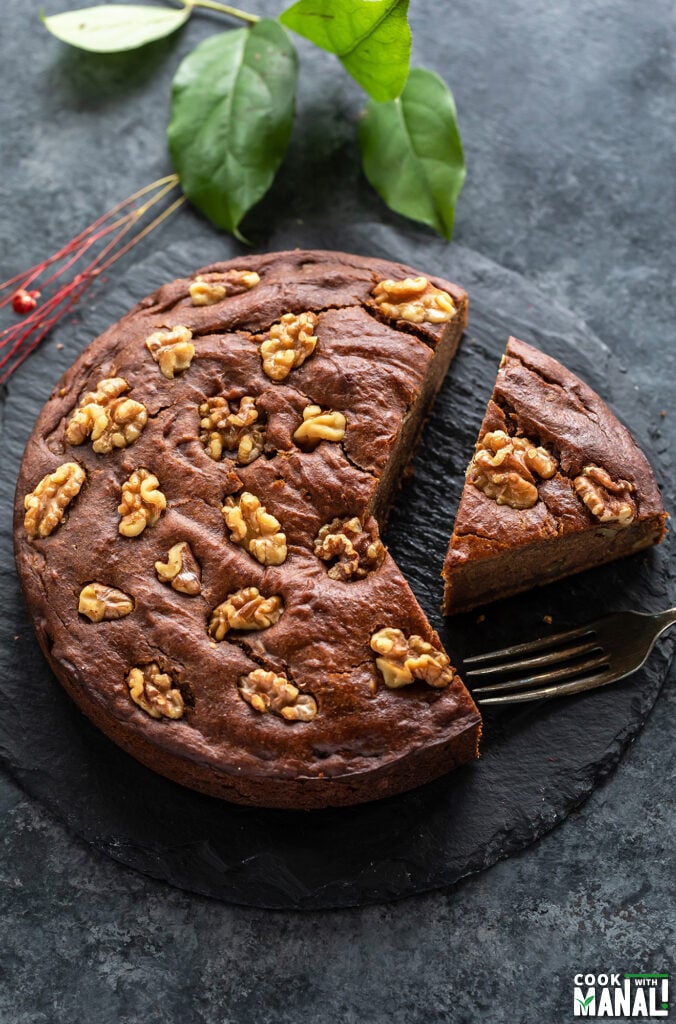 a slice of date walnut cake cut from the cake and placed on a serving board