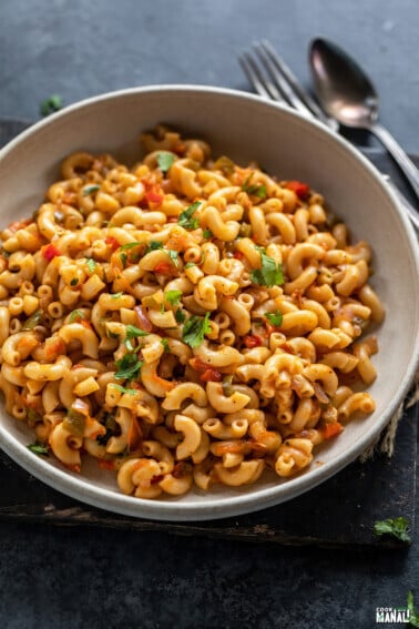 masala macaroni served in a bowl and garnished with cilantro