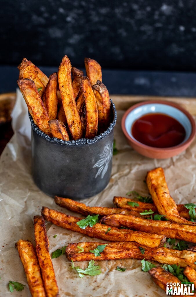 french fries served in an antique glass with a bowl of ketchup on the side