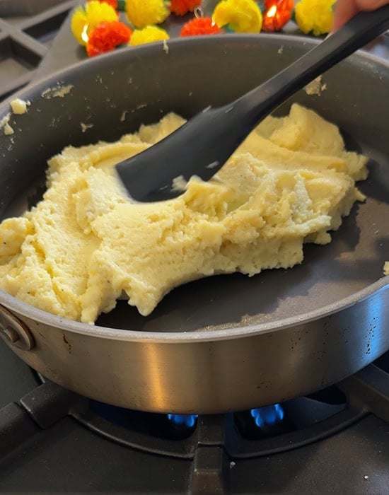 milk powder leaving the sides of the pan with a black spatula stirring it