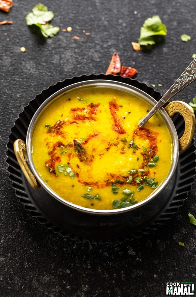 moong dal tadka in a copper kadai with a garnish of cilantro and cumin