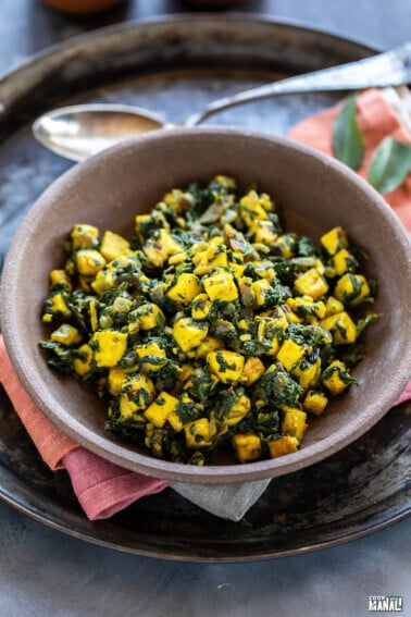 paneer and spinach stir fry served in a brown color bowl