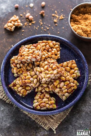 overhead shot of peanut chikki squares in a blue plate