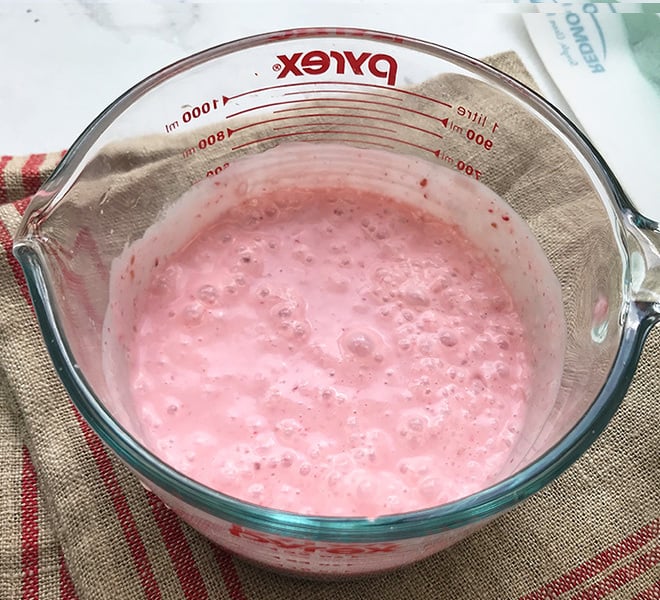raspberry coconut lassi in a large measuring jar