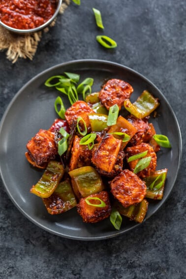 paneer cubes tossed in sauce garnished with green onions