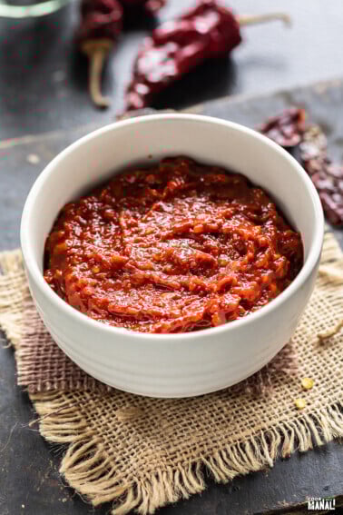 red color thick sauce in a white bowl with some red chilies place in the background