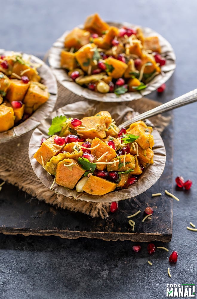 three bowls of sweet potato chaat topped with pomegranate, cilantro and sev