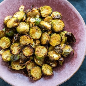 roasted brussel sprouts served in a pink color plate